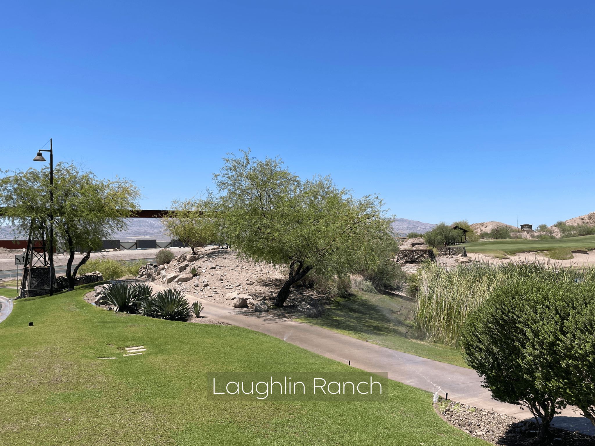 Scenic golf course with lush greenery and clear blue sky at Laughlin Ranch.